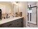 Bathroom features a double sink vanity with a quartz countertop and a glass-enclosed shower at 9837 E Aberdeen Ave, Englewood, CO 80111