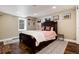 Bedroom featuring hardwood floors, a comfortable bed, and two windows that provide natural light at 9837 E Aberdeen Ave, Englewood, CO 80111