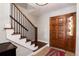 Welcoming home foyer featuring a staircase with wood and iron railing and a unique front door at 9837 E Aberdeen Ave, Englewood, CO 80111