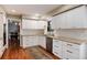 Charming kitchen featuring white cabinetry, granite countertops, stainless steel appliances and wood floors at 9837 E Aberdeen Ave, Englewood, CO 80111