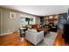 Cozy living room features a brick fireplace and built-in shelves, with hardwood floors and a large window at 9837 E Aberdeen Ave, Englewood, CO 80111