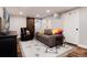 Finished basement with a comfortable sofa, a leather armchair, and a large decorative rug at 9837 E Aberdeen Ave, Englewood, CO 80111