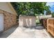 Storage shed in a backyard with a brick home, concrete path, and wood fence at 9837 E Aberdeen Ave, Englewood, CO 80111