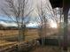 Picturesque backyard view showcasing a sprawling field and mountains, framed by a rustic wooden fence at 3231 Lump Gulch Way, Erie, CO 80516