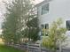 Backyard showcasing a home's architecture framed by mature trees and a wooden fence at 3231 Lump Gulch Way, Erie, CO 80516