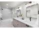 Bright bathroom features a double sink vanity with quartz countertops, soaking tub and tiled shower at 1571 Vrain St, Denver, CO 80204