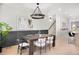 Dining room with a wooden table, stylish chairs, chandelier lighting, and decorative wall paneling at 1571 Vrain St, Denver, CO 80204