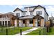 Modern two-story home with white siding, black trim, manicured lawn, and a black metal fence at 1571 Vrain St, Denver, CO 80204