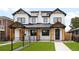 Modern two-story home with white siding, black trim, manicured lawn, and a black metal fence at 1571 Vrain St, Denver, CO 80204