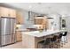 Modern kitchen featuring stainless steel appliances, a large island with seating, and stylish pendant lighting at 1571 Vrain St, Denver, CO 80204