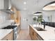 Bright kitchen with modern stainless appliances, a large island with a sink, and minimalist cabinets at 1571 Vrain St, Denver, CO 80204