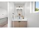 This powder room has a wood vanity, quartz countertop, and a sleek mirror for a modern touch at 1571 Vrain St, Denver, CO 80204