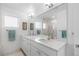 Bright bathroom featuring a double vanity, large mirror, and modern lighting fixtures at 3725 N Franklin St, Denver, CO 80205