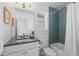 Modern bathroom with blue tiled shower, white vanity, and a large mirror above the sink at 3725 N Franklin St, Denver, CO 80205