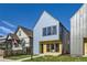 Charming two-story home featuring light blue siding, black trim windows, and a well-manicured lawn at 3725 N Franklin St, Denver, CO 80205
