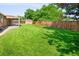 Large backyard featuring lush green grass, mature trees, and privacy fencing at 6353 W 78Th Ave, Arvada, CO 80003