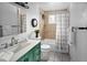 Bathroom with a stylish green vanity, tiled shower, and decorative black clock at 6353 W 78Th Ave, Arvada, CO 80003