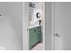 Bathroom featuring a green vanity, toilet, framed mirror, and decorative accents at 6353 W 78Th Ave, Arvada, CO 80003