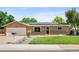Charming single-story home featuring a well-manicured lawn, and solar panels on the roof at 6353 W 78Th Ave, Arvada, CO 80003