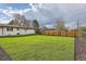 Wide open backyard with lawn, wood fence, and rear exterior view of the home at 2076 S Yates St, Denver, CO 80219