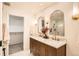 Elegant bathroom featuring double vanity, decorative mirrors, and walk-in closet access at 2076 S Yates St, Denver, CO 80219