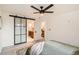 Bedroom with ceiling fan, sliding glass barn door, and view of adjacent bathroom at 2076 S Yates St, Denver, CO 80219
