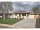 Beautiful single-story home with a well-manicured lawn and a wide driveway leading to an attached one-car garage at 2076 S Yates St, Denver, CO 80219