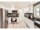Well-appointed kitchen with stainless steel appliances, white cabinets, updated countertops, and modern fixtures at 2076 S Yates St, Denver, CO 80219