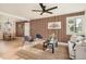 Cozy living room featuring wood slat accent wall, a comfortable seating area, and an open layout to the dining room at 2076 S Yates St, Denver, CO 80219