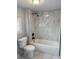 Stylish bathroom featuring a modern tub with gray, marbled tile surround and a sleek, matte black shower fixture at 2619 S Bannock St, Denver, CO 80223