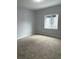 Comfortable bedroom featuring neutral walls, plush carpeting, and a sunlit window, creating a bright and cozy space at 2619 S Bannock St, Denver, CO 80223