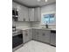 Updated kitchen with stainless steel appliances, gray cabinets, and neutral walls and marble tile floors at 2619 S Bannock St, Denver, CO 80223