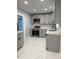 Modern kitchen featuring gray cabinets, stainless steel appliances, and stylish marble tile flooring at 2619 S Bannock St, Denver, CO 80223