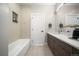 Well-lit bathroom featuring a modern tub, shower, and a sleek double sink vanity at 3485 S Clermont St, Denver, CO 80222