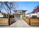 Contemporary two-story home with mixed materials, a driveway, modern garage door and a partially fenced front yard at 3485 S Clermont St, Denver, CO 80222