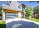 Attractive modern home with gray siding, wood accents, well-kept lawn, and glass garage doors, combining style and functionality at 3485 S Clermont St, Denver, CO 80222