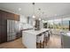 Bright kitchen with stainless steel appliances, large island with seating, pendant lights and large windows at 3485 S Clermont St, Denver, CO 80222