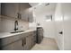 Well-lit laundry room with gray cabinets and modern appliances at 3485 S Clermont St, Denver, CO 80222