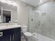 Updated bathroom with a glass shower enclosure, marbled tile, and navy blue cabinets at 5439 Verbena St, Denver, CO 80238