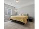 Bedroom with carpet, a large window, and a yellow comforter with neutral colored pillows at 5439 Verbena St, Denver, CO 80238