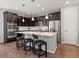 Modern kitchen featuring stainless steel appliances, a large island with seating, granite countertops and dark cabinets at 5439 Verbena St, Denver, CO 80238