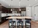A kitchen with stainless steel appliances, a large island with seating, granite countertops and dark cabinets at 5439 Verbena St, Denver, CO 80238