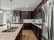 A kitchen with stainless steel appliances, granite countertops, dark cabinets and white subway tile backsplash at 5439 Verbena St, Denver, CO 80238