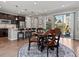 Open concept kitchen and dining area featuring wood floors, a modern table, and plenty of natural light at 5439 Verbena St, Denver, CO 80238