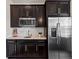 Modern kitchenette features stainless steel appliances, dark cabinets, granite countertops, and a convenient sink at 5439 Verbena St, Denver, CO 80238