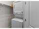 Efficient laundry area with stacked washer and dryer units and convenient shelving at 5439 Verbena St, Denver, CO 80238