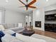 Cozy living room with a stylish fireplace, a ceiling fan, and comfortable seating for relaxing and entertainment at 5439 Verbena St, Denver, CO 80238