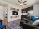 Open-concept living room with a comfortable sectional couch, sleek shelving, and hardwood flooring at 5439 Verbena St, Denver, CO 80238