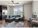 Bright living room featuring hardwood floors, a stylish black sectional couch, and large windows at 5439 Verbena St, Denver, CO 80238