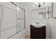 Updated bathroom with tub and dark vanity at 5547 S Lowell Blvd, Littleton, CO 80123